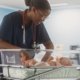 An image of a nurse caring for a newborn baby in a hospital cot