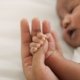 An image of a baby holding someone's hand