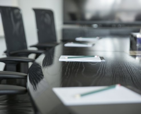 An image of a round table in an empty boardroom